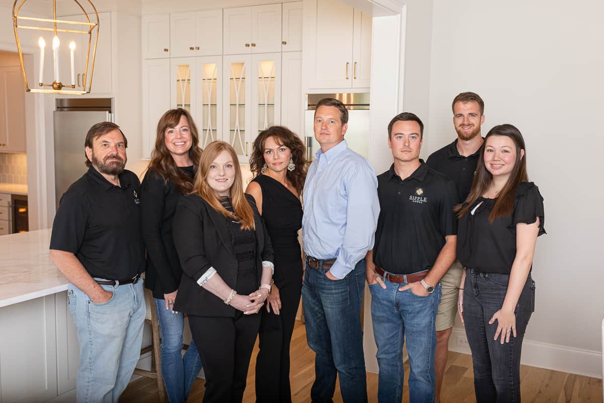 Team photo of builders and designers inside a model home.